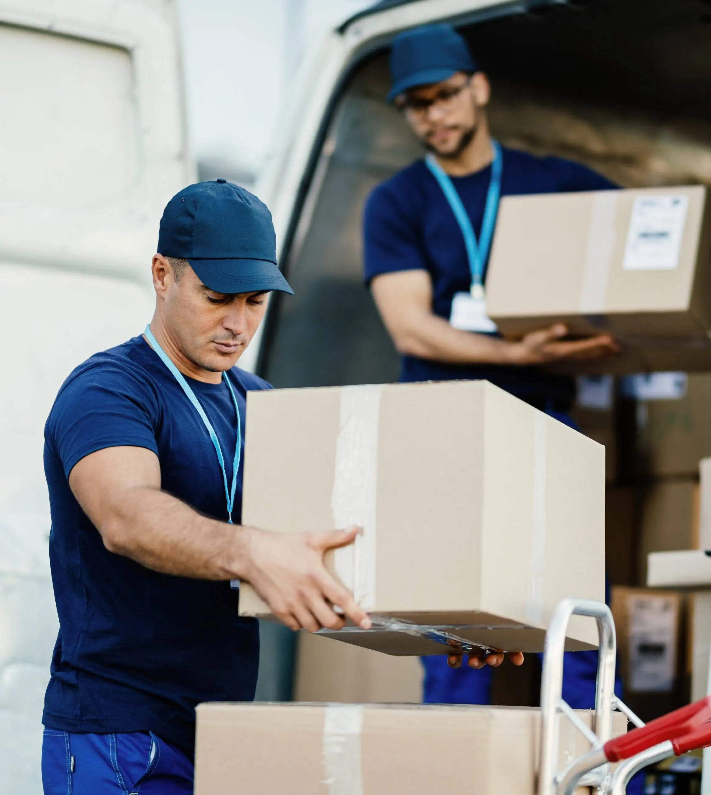 The Benefits of Hiring Professional Movers in Winnipeg: Why DIY Moves Can Be a Recipe for Disaster Young delivery man and his coworker unloading boxes from a van.